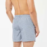 Short de baño celeste con estampado de motivos geométricos en azul y cordón blanco ajustable en la cintura.
