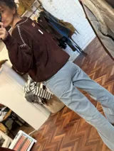 Sweater tejido en mohair color mostaza, con cuello redondo y bordados en hilo de seda. Corte clásico y mangas largas.