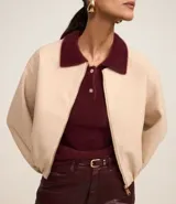 Campera bomber color beige con cuello y puños en color borgoña. Cierre frontal con cremallera y bolsillos laterales.