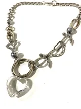 Collar plateado de acero quirúrgico con dijes colgantes de acero y un dije de corazón de vidrio transparente.