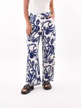 Pantalón palazzo con estampado de hojas y flores en tonos azul y blanco.