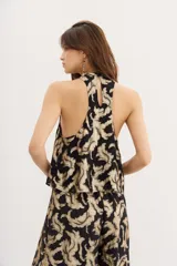 Top negro de viscosa jacquard con lurex dorado, corte halter, frunces en el escote y espalda descubierta con cierre de botón.