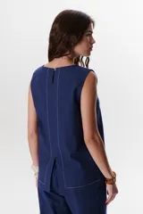 Top sin mangas confeccionado en mezcla de lino y algodón color marrón, con escote en V y pespuntes blancos decorativos en contraste.