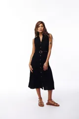 Vestido midi negro de algodón, sin mangas, con cuello camisero, abotonado al frente y cinturón con hebilla redonda.