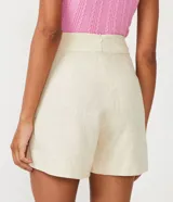 Short color beige confeccionado en viscolino con detalle de pliegues diagonales y cierre de cremallera.