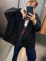 Campera negra de bouclé con cierre frontal y bolsillos de parche. Corte amplio y mangas largas.