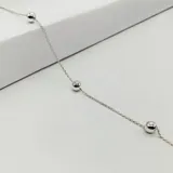 Pulsera de plata 925 con eslabones finos y dijes de bolitas plateadas.