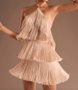 Vestido corto de fiesta color beige con escote halter y falda con flecos en capas.