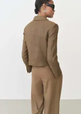 Chaqueta corta color marrón con cuello de solapa y cierre frontal con botones.