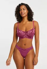 Conjunto de lencería color violeta, compuesto por un soutien con aro de encaje floral y micro tul, con breteles regulables, y una tanga de micro tul con detalle de encaje floral en la cintura.