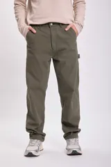 Pantalón verde de corte recto, estilo carpintero, con múltiples bolsillos y presillas para herramientas.
