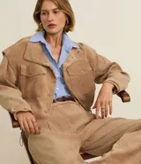 Pantalón recto de cintura alta, confeccionado en terciopelo cotelé color beige, con trabillas en la cintura, cierre tradicional y bolsillos delanteros.