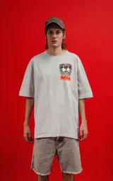 Remera color gris claro de corte oversize, con cuello redondo y mangas cortas. Estampado en la espalda con Mickey y Minnie Mouse sentados sobre una roca, con llamas y el texto 'Hello Darling'.