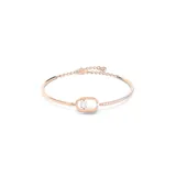 Pulsera de metal con baño en tono oro rosa, estilo brazalete abierto. Presenta un diseño central con una piedra redonda brillante suspendida dentro de una estructura ovalada. Un lado del brazalete está adornado con una hilera de cristales engastados.