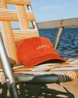 Gorro de pana color mostaza con visera y bordado frontal con la palabra "Yamba".