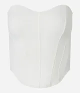 Blusa tipo corset color crema, sin breteles, confeccionada en crepé con bajo asimétrico alargado.