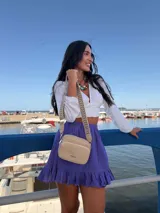 Bandolera pequeña de símil cuero color beige, con dos compartimentos frontales con cierre. Incluye una correa ancha ajustable con diseño estampado en tonos beige y negro.