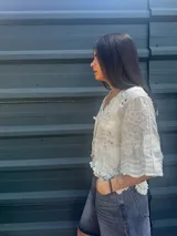 Camisa negra con detalles de crochet color crema, escote en V y mangas 3/4.