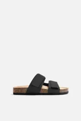 Sandalias negras con dos tiras anchas en el empeine con acabado engomado y ajustables mediante cierres adherentes. Plantilla con horma anatómica y suela de corcho.