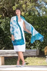 Echarpe blanca de gasa de seda natural con lana Merino superfina en tonos azules y turquesas, con volados en los extremos.