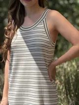 Vestido largo de punto, negro con rayas horizontales blancas, corte recto y sin mangas.