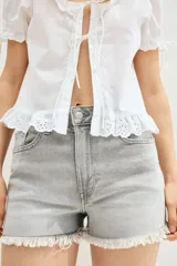 Short de denim gris con tiro alto, cinco bolsillos, corte relajado y terminación desflecada.