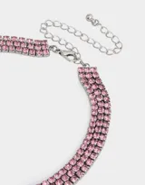 Gargantilla con triple hilera de strass rosa y dije de mariposa plateada con strass.