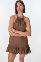 Vestido corto color beige, con escote halter, tirantes finos y falda con volados.