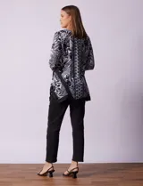 Blusa estampada en blanco y negro con diseño floral, de la marca Ruby Rd. Tiene cuello redondo con apliques de brillos, mangas 3/4 y ruedo asimétrico.
