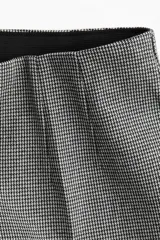 Pantalón de vestir con estampado pata de gallo en tejido levemente elástico, tiro alto, elástico oculto en la cintura y pinzas adelante y atrás. Piernas ajustadas con pliegues.
