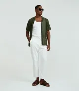 Pantalón masculino de corte relaxed, color blanco, confeccionado en tejido Oxford de algodón. Presenta cintura con trabillas y cordón para lazo, bolsillos delanteros y traseros.