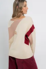 Buzo de punto color crudo con bloques geométricos en beige y marrón. De calce amplio y tejido suave al tacto, con terminación en ruedo redondeado.