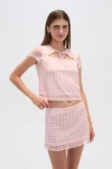 Top negro de poliéster con mangas cortas, cuello redondo, corte ajustado y abertura en el pecho.