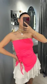 Top strapless fucsia con frunce lateral y corte irregular.
