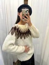 Sweater tejido a mano en Uruguay con lana merino color crudo, con diseño geométrico en tonos marrón y beige en la parte superior.