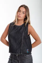 Blusa denim sin mangas, color negro, con detalle de recortes y parche BG.