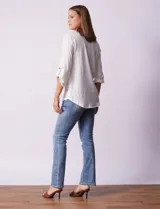 Blusa blanca texturizada marca Ninety, con cuello a la base, escote en V, abertura central con botones, bolsillo delantero y mangas tres cuartos regulables con presilla y botón.