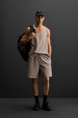 Bermuda jogger negra confeccionada en tejido de algodón con interior de rizo, cintura elástica ajustable con cordón y bolsillos laterales.