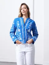 Chaqueta azul de algodón y lino con bordado floral blanco, cuello mao y cierre frontal con botones.