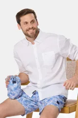 Short de baño celeste con estampado de hojas en tonos azul y rosa. Incluye bolsa de tela con el mismo estampado.