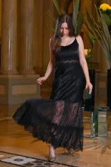 Vestido largo negro con breteles finos, corte debajo del busto con detalle de encaje y falda de encaje con volados.
