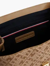 Mochila Tommy Hilfiger color beige con monograma de la marca en jacquard. Tiene asa superior, correas ajustables, cierre de solapa, compartimento principal y detalles distintivos de la marca.