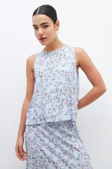 Blusa celeste con estampa floral, sin mangas.