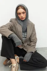 Balaclava tejida gris melange con capucha y cordones ajustables.