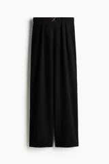 Pantalón sastre negro de punto crepé con pinzas, tiro alto, cintura elástica, cinturón decorativo con hebilla metálica y piernas amplias rectas.
