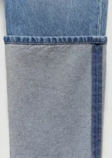 Pantalón de jean celeste de corte recto con ruedo gris.