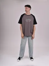 Remera blanca con mangas ranglán color gris y estampado frontal con la palabra "Michigan" en verde.