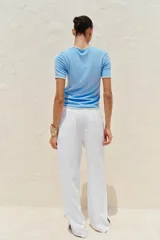 Remera blanca de punto con cuello redondo y mangas cortas con ribete negro en cuello, mangas y ruedo.