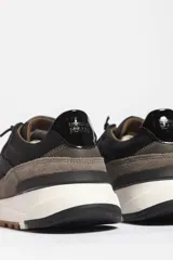 Zapatillas deportivas color beige con detalles en marrón y amarillo.