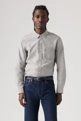 Camisa de chambray gris claro, de corte estándar, con cuello abotonado, manga larga, bolsillo de parche en el pecho y cierre frontal con botones.